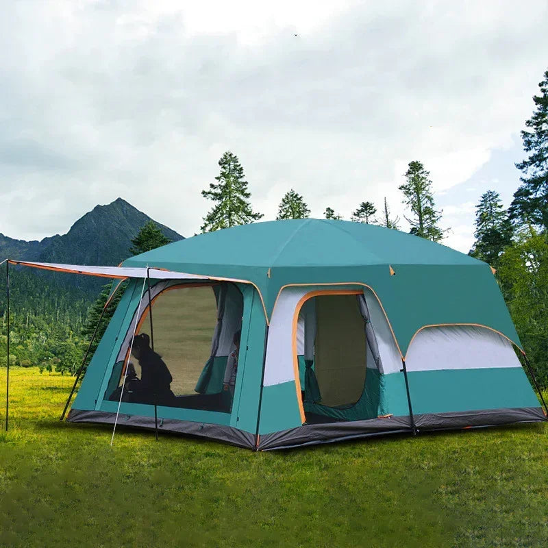 Spacious green camping tent set up outdoors on grass with mountains and trees in background