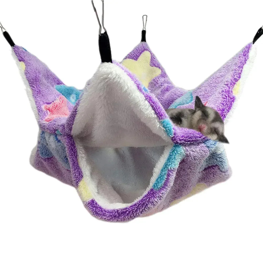 Small pet sleeping in soft purple hammock bed with star patterns, cozy outdoor gear for animals